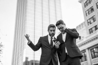 İş adamları iş konuşmalarını kontrol ediyor. İş adamları dışarıda serbest çalışıyor. İnternette iş. Telefonla çalışan adamlar. Çevrimiçi çalışan iş adamları. Takım elbiseli telefonlu iş adamları. Çalışıyorum. Boşluğu kopyala.