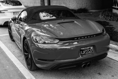 Miami Beach, Florida USA - 9 Haziran 2024: 2018 Porsche 718 Boxter 's orange color at Miami Beach. Ocean 'daki lüks Porsche Miami plajına gidiyor. arka plan