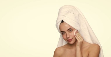 Makyajı sil. Güzellik rutini. Havluyla yüz temizleyen kadın derisi. Pamuk yumağıyla deriyi temizliyor. Cilt kozmetolojisi. Kaplıcada güzellik günü. Kadın pamuk pedi kullanıyor. Cilt bakımı. Boşluğu kopyala.