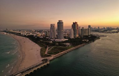Gece şehri hava manzarası. Miami, Florida 'da lüks bir gökdelen. Akşam günbatımında şehir silüeti. Havadan şehir manzarası. Gece Miami South plajı. İyi akşamlar güzellik. Geceleri gökdelen şehir manzarasında hava manzarası.