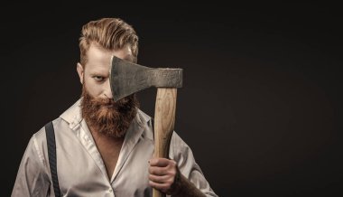 Antika pantolon askılı, eski tip bir gaddar adam. Siyaha izole edilmiş baltalı askılı vahşi bir adam. Saçları kızıl saçlı, olgun bir adam. Acımasız erkek modası. Erkek vahşeti. Boşluk afişini kopyala.