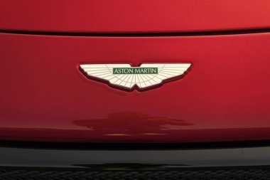 Chicago, Illinois, ABD - 08 Eylül 2024: Aton Martin kırmızı arka planda. İngiliz lüks spor araba üreticisi Aston Martin 'in logosu 1913' te kuruldu...