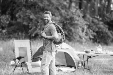 Yürüyüş konsepti. Kamp çadırı. Ormanda çadırda çadırda bir adam var. Bir yaz günü doğa yürüyüşçüsü. Yaz kampı ve doğa tatili. Yaz kampındaki adam. Kamp macerası. Sırt çantası yolculuğu.