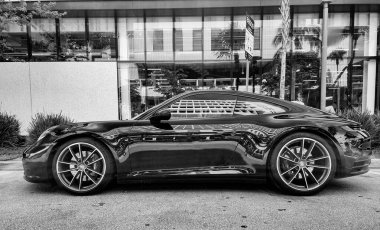 Miami Beach, Florida USA - 8 Haziran 2024 Porsche 911 Carrera 4S Miami Beach 'te siyah. Ocean 'daki lüks araba porshche Miami plajına gidiyor..