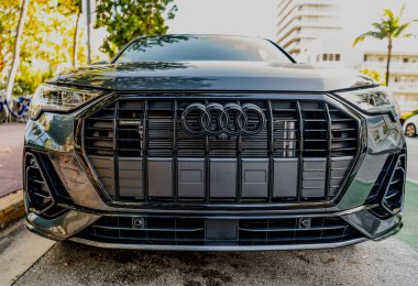 Miami, Florida, ABD - 07 Nisan 2025: Audi Q3 numaralı araba açık havada park edilmiş. Koyu yeşil kesişen araba, ön görüş. 2025 Audi Q3 hibrit coupe crossover araba. Coupe crossover araba Audi Q3.