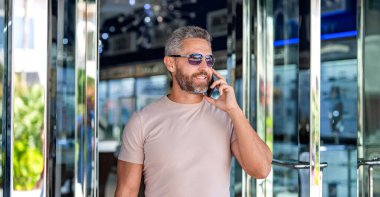 Sıradan bir iş adamı dışarıda telefonla konuşuyor. Telefon kullanan bir iş adamı. Erkek telefon konuşması. Akıllı telefonlu İspanyol bir iş adamı. İş iletişimi. Telefona cevap veren adam. Hızlı yanıt.