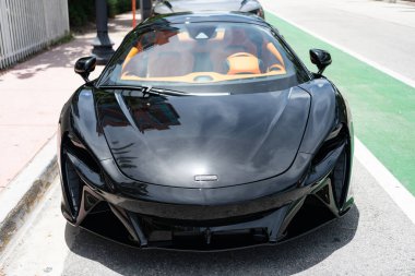 Miami, Florida, ABD - 27 Temmuz 2025: McLaren GT 2022 spor araba. Lüks siyah spor araba McLaren GT. McLaren GT 'nin arabası dışarı park edilmiş, ön manzara..