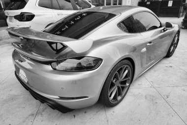 New York, ABD - 10 Mart 2024: Porsche 718 Cayman lüks araba gümüş rengi açık hava, arka köşe manzaralı.