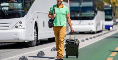 Bavullu sıradan giysili bir gezgin. İnsan hafta sonu yurt dışına çıkıyor. Seyahat yaşam tarzı. Yaz şehrinde bir turist. Seyahat çantası. Amerika 'ya yaz gezisi. Miami 'de olgun bir turist..