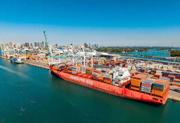 Miami, Florida, USA - March 20, 2025: Cargo Hamburg Sud ship services with container in Miami, aerial view. Freight container on cargo vessel. Cargo ship vessel. Miami port. Container ship.