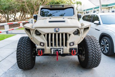 Miami, Florida, ABD - 16 Şubat 2025: Araba Jeep Gladyatörü açık havada park etti. Bej kamyonet, ön manzara. Jeep Gladyatör 2024 arabası. Kamyonet arabası Jeep Gladyatörü.