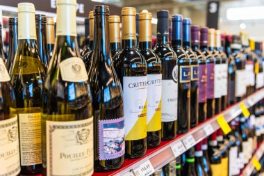 Seattle, Washington, ABD - 14 Temmuz 2024: sırada bir şişe şarap. Şarap dükkanı. Mağaza rafında çeşitli şarap şişeleri sergileniyor. Alkol perakende dükkanı. Şarap dükkanı. Süpermarkette alkol bölümü..