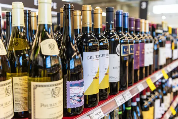 Seattle, Washington, ABD - 14 Temmuz 2024: sırada bir şişe şarap. Şarap dükkanı. Mağaza rafında çeşitli şarap şişeleri sergileniyor. Alkol perakende dükkanı. Şarap dükkanı. Süpermarkette alkol bölümü..