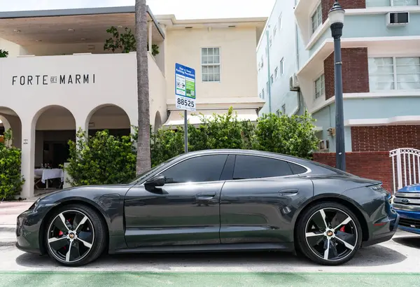 Miami, Florida, ABD - 12 Temmuz 2025: Porsche Taycan 2020 elektrikli araba. Lüks elektrikli Porsche Taycan. Porsche Taycan dışarıda park etmiş. Siyah elektrikli araba, yan görüş..