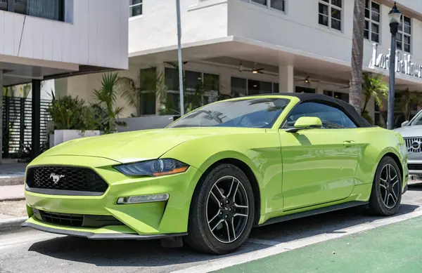 Miami, Florida, ABD - 21 Nisan 2025 Ford Mustang EcoBoost üstü açılabilir araba. Üstü açık spor araba Ford Mustang EcoBoost. Araba Ford Mustang park etmiş. Yeşil üstü açık araba, köşe manzaralı..