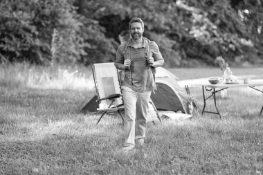 Ormanda çadırda çadırda bir adam var. Bir yaz günü doğa yürüyüşçüsü. Yaz kampı ve doğa tatili. Yaz kampındaki adam. Kamp macerası. Yürüyüş konsepti. Kamp çadırı. Doğa kaçamağı.