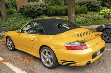 Chicago, Illinois - 29 Eylül 2024: Porsche 911 Turbo Carrera S sarı renk. Porsche 911 Turbo Carrera S yola park etti. ön görünüm