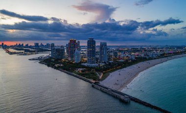 Miami sahil şeridinin hava gece görüşü. Miami Okyanusu 'nun üzerindeki alacakaranlık silueti. Miami Sahili kıyısı gün batımından sonra parlıyordu. Gökten ünlü Miami Sahili