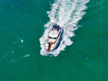 Motorlu teknenin üst hava manzarası. Marinaya yüzen bir tekne. Yaz denizi kıyısında bir tekne turu. Denizdeki lüks yat teknesi. Yaz tatili. Lüks yat teknesi manzarası.