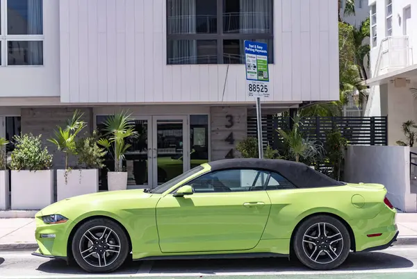 Miami, Florida, ABD - 21 Nisan 2025 Ford Mustang EcoBoost üstü açılabilir araba. Üstü açık spor araba Ford Mustang EcoBoost. Araba Ford Mustang park etmiş. Yeşil üstü açık araba, yan görüş..