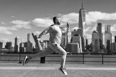 Aktif kıyafet eğitimi alan sporcu New York 'ta spor için spor minderiyle koşuyor..