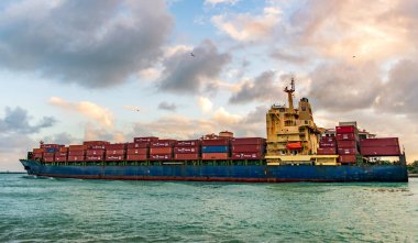 Miami, Florida, ABD - 16 Aralık 2024: konteyner gemisi. Yük Chloe D Monrovia gemisi, konteynır, insansız hava aracı görüşlü. Kargo gemisinde nakliye konteynırı. Kargo gemisi. Gün batımında Miami Limanı.