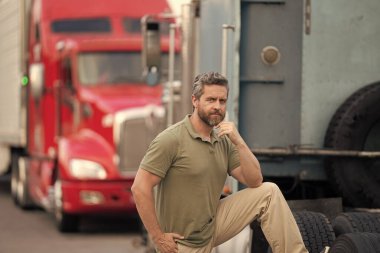 Kamyonun önünde yakışıklı bir şoför. Kamyon sahibi. Kamyon şoförü. Kamyon kamyonunun yanında bir erkek kamyon şoförü. Nakliye araçları. Yarı kamyon aracı. İspanyol kamyoncu adam. İşçi Bayramı.