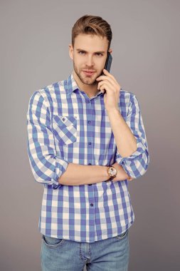 Millennial Man 'e telefon var. Cep telefonuyla konuşan bir adam. Telefon var. Mobil bağlantı. Kulaklıklı adam. Öğrenci yaşam tarzı. Modern iletişim. Telefonda konuşan adam Grey 'i izole etti. Sesli mesaj..