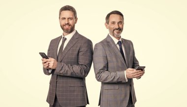 Telefondaki mesajlaşan iş adamları beyazdan izole edilmiş. İş mesajlaşması. İnternet işi. Takım elbiseli iş adamları telefon kullanır. Blogda sohbet eden iki iş adamı.