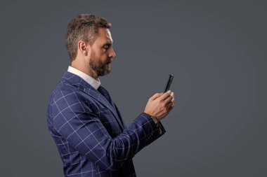 Gri yolda insan telefonu görüşmesi izole edildi. İş adamı sohbeti. İş adamı mesajlaşması ve mesajı. Sosyal ağ. Telefonu olan İspanyol bir iş adamı. İş adamı telefonu kullanmakla meşgul..