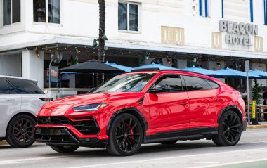 Miami, Florida, ABD - 8 Nisan 2025: lüks turuncu SUV araba Lamborghini Urus. Lamborghini Urus 'un arabası dışarı park edilmiş, köşe manzaralı. Lamborghini Urus 2021 lüks SUV kırmızı.