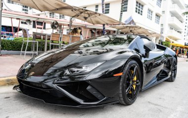 Miami, Florida, ABD - 13 Temmuz 2025 Lamborghini, köşe manzaralı. Lamborghini Huracan EVO 2020 üstü açık araba. Lüks siyah araba Lamborghini Huracan EVO. Lamborghini Huracan 'ın arabası dışarı park edilmiş..