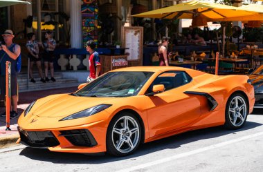 Miami, Florida, ABD - 26 Temmuz 2025: lüks spor arabası Chevrolet Corvette C8. Üç araba Chevrolet Corvette C8 turuncu renkli, dışarıda park edilmiş, köşe manzaralı. Chevrolet Corvette C8 spor araba.
