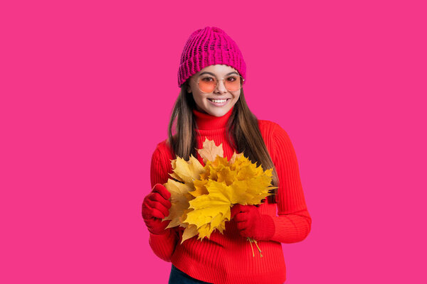 Autumn girl hold fallen leaves. Fall and autumn. Autumnal season. Fall fashion. Happy young girl playfully hold yellow maple leaves. Teen girl with fallen leaves isolated on pink.