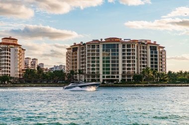 Marinaya yüzen bir tekne. Fisher Adası 'nda lüks bir yat teknesi. Yaz tatili. Fisher Adası konut binası ve lüks yat teknesi. Miami 'de Fisher Adası' na yat gezisi..