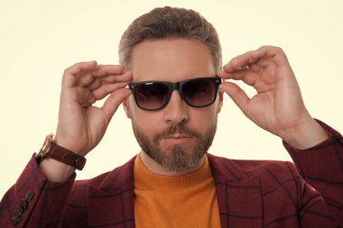 Beyaz giysili şık erkek kıyafetleri. İş ceketli ve güneş gözlüklü bir adam. Olgun adam erkek giyim tarzı giyinir. Şık ve modaya uygun. İspanyol manken. Şık bir portre.