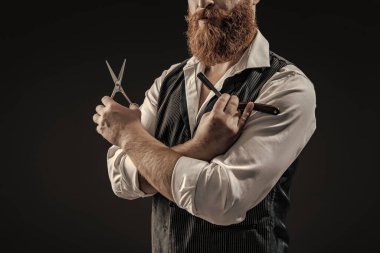 Saç keserken makas ve retro bıçak kullanan yakışıklı berber. Modern berber saç kesimi. Siyah sakallı hippi berber. Berberdeki kuaförden sakal kesimi. Taze saç kesimi.