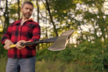 Vahşilik ve erkeklik. Baltalı oduncu seçici odaklı. Acımasız oduncu. Ormandaki oduncu. Baltalı bir adam. Balta adamın elinde odun kesiyor. Odun kesiyorum. Keskin bıçak.