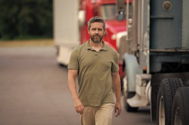 Kamyonun önünde yakışıklı bir şoför. Kamyon sahibi. Kamyon şoförü. Kamyon kamyonunun yanında bir erkek kamyon şoförü. Nakliye araçları. Yarı kamyon aracı. İspanyol kamyoncu adam. Dağıtım.