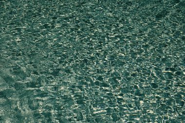 Mavi havuz arka planında deniz dalgaları. Deniz arka planı. Yüzme havuzu dalgalandı. Yaz tatili. Yaz tatilinde spa merkezi. Havuz kenarında su yüzeyi olan bir tatil köyü. Hafta sonu kaçamağı.