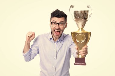 İş başarısı. İş adamı zaferi beyazlarla izole edilmiş iş görüşmeleriyle kutluyor. Şampiyon kupasını elinde tutan başarılı bir iş adamı. Ticari başarı. Seçici odak.