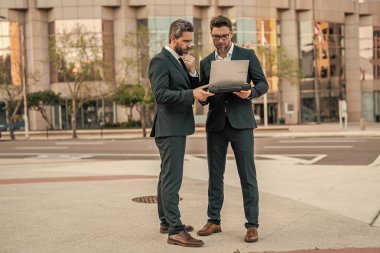 İş adamları e-postaları kontrol ediyor. İş adamları dışarıda serbest çalışıyor. İnternette iş. Dizüstü bilgisayarda çalışan adamlar. Çevrimiçi çalışan iş adamları. Dizüstü bilgisayarlı iş adamları. Çalışıyorum. Bir projeyi tartışın.