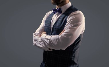 Zarif siyah takım elbiseli şık bir adam. Smokinli bir beyefendi. Resmi etkinlikteki iş adamı. Damadın smokin tarzı var. Centilmen smokini. Smokin, kesilmiş. Papyonlu adam gride izole edilmiş. Terzi kıyafeti..