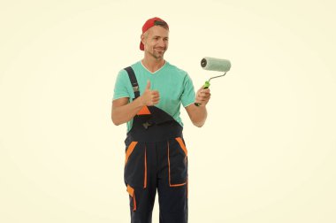 Ressamı yeniliyorum. Ev tadilatı. Boyacı adam boya silindiri tutuyor. Dekoratör için boya silindiri. Tadilat işi. Dekoratör boyama yapıyor. Yenileyen adam beyazda izole edildi. Başparmak yukarı..