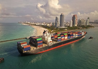 Konteyner gemisi. İhraç ve ithalat. Kargo işi. Miami Limanı. Miami 'de konteynırlı kargo gemisi, anten. Kargo gemisinde nakliye konteynırı. Kargo gemisi limandan ayrılıyor. Verimli taşıma.