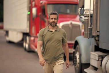 Kamyonun önünde yakışıklı bir şoför. Kamyon sahibi. Kamyon şoförü. Kamyon kamyonunun yanında bir erkek kamyon şoförü. Nakliye araçları. Yarı kamyon aracı. İspanyol kamyoncu adam. Mesleki meslek.