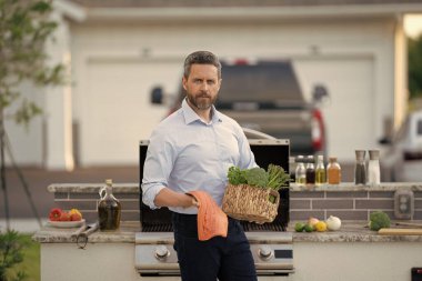 Izgara ve mangal. Şef mutfakta çiğ balık somonu pişirdi. Restoran menüsü. İspanyol şef balık filetosu tutuyor. Baharatlı somon. Somon filetosu. Arka bahçede ızgarada kızarmış balık filetosu..