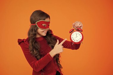 Tatil eğlencesi bitti. Geri sayım. Geç kalan kız portakallı. Geç saatte. Parti geri sayımı. Parti maskeli neşeli genç kız saati işaret ediyor. Parti sonrası eve geç gelen kız..