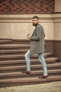 Sabah kahvesi içen adam. Kahve molası. Günlük stil rutini. Sakallı adam şehir caddesinde kahve içiyor. Sokakta kahve tutan yakışıklı bir adam. İş hayatı, mola. İşe giderken..