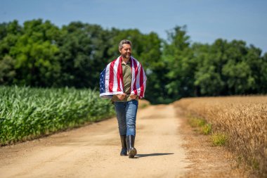 Amerika 'nın Bağımsızlık Günü. 4 Temmuz. Amerikan İşçi Bayramı. Amerikan bayrağı ve çiftçi adam. ABD bayrağı. Bağımsızlık Günü. Sahadaki adam. Ekin tarlasında Amerikan bayrağı taşıyan adam. Özgürlüğü onurlandırmak.